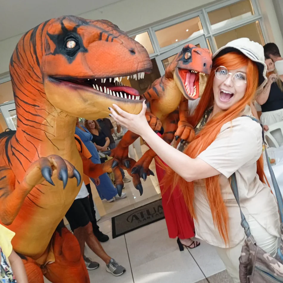 Equipe guiando Velociraptor Laranja Personagem Vivo em salão de festas infantis