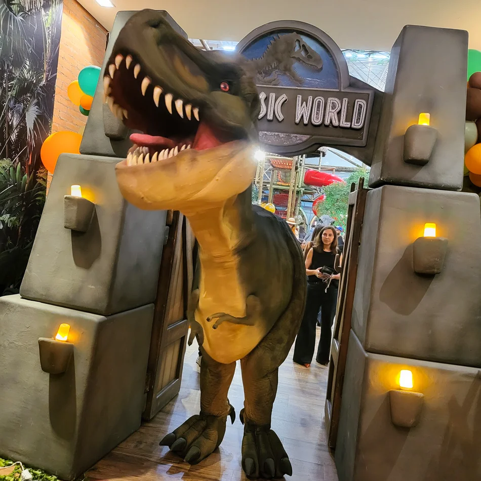 T-Rex Personagem Vivo gigante surpreendendo convidados na hora do parabéns em buffet infantil